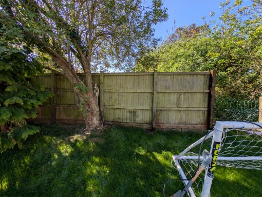 Timber fence with heavy dirt and algae build-up before pressure washing in Onehouse, Suffolk