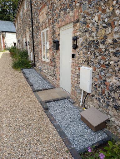 Front beds, fully weeded, with decorative aggregate put down and retaining setts installed for edging