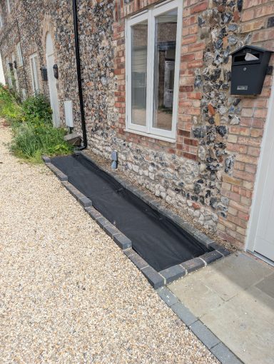 The same front bed after having membrane put down to prevent future growth of weeds