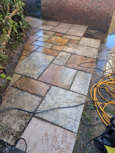 Heavily weathered patio area after pressure washing