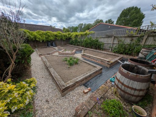 New weed membrane installed around established raised beds